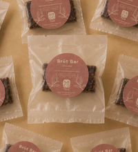 Brüt Bar chocolate mini packages arranged on a beige background