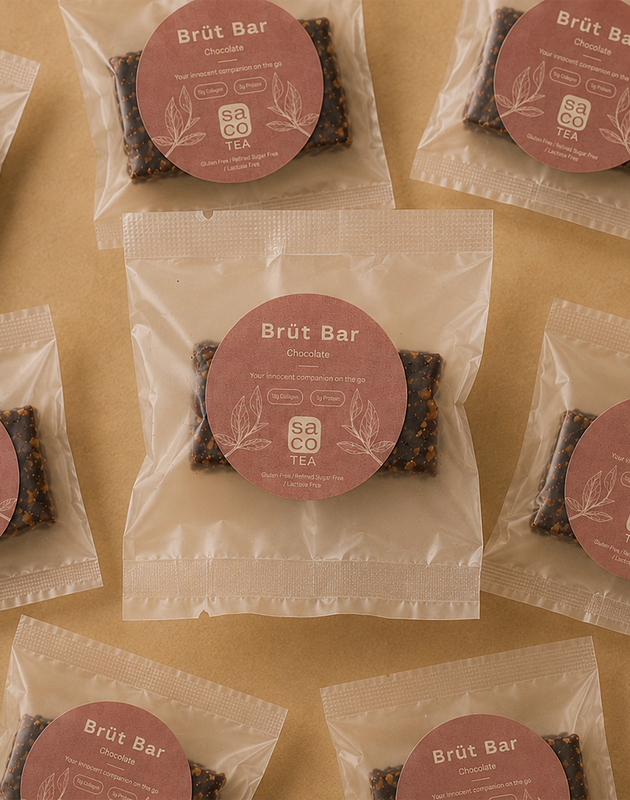 Brüt Bar chocolate mini packages arranged on a beige background