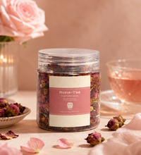Jar of Rosie Tea with pink label beside rose petals, a cup of tea, and soft floral styling.
