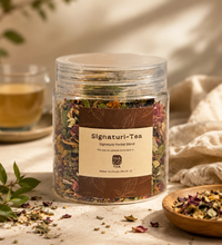 Jar of Signaturi-Tea with dried herbs on a table with a cup of tea and a wooden bowl.