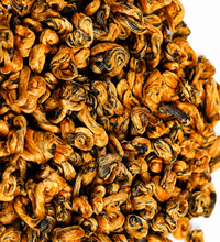 Close-up of Blacko Tea loose black tea leaves with golden curled tips on a white background