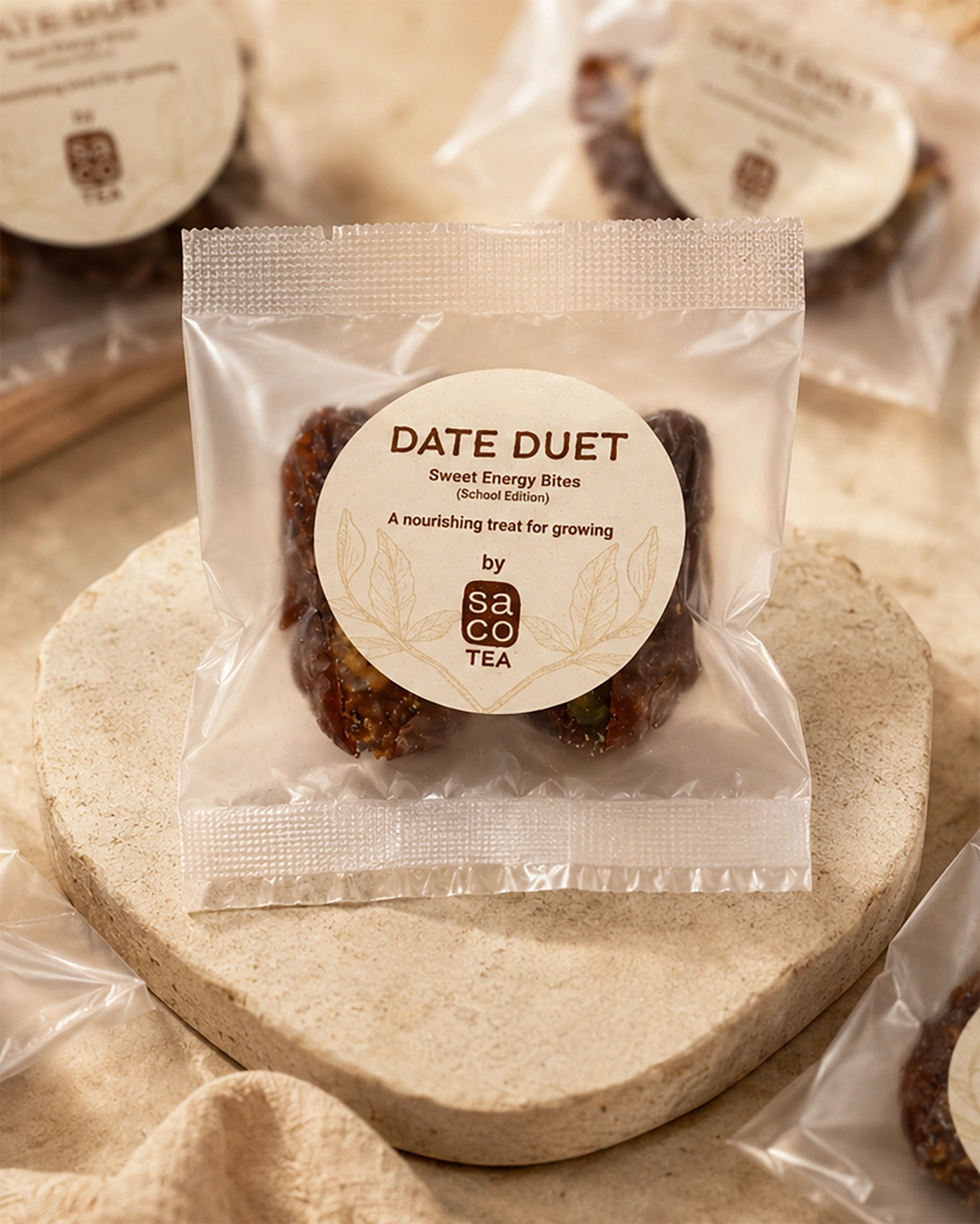Packaged Date Duet bites with Saco Tea label on a stone surface