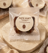 Packaged Date Duet bites with Saco Tea label on a stone surface