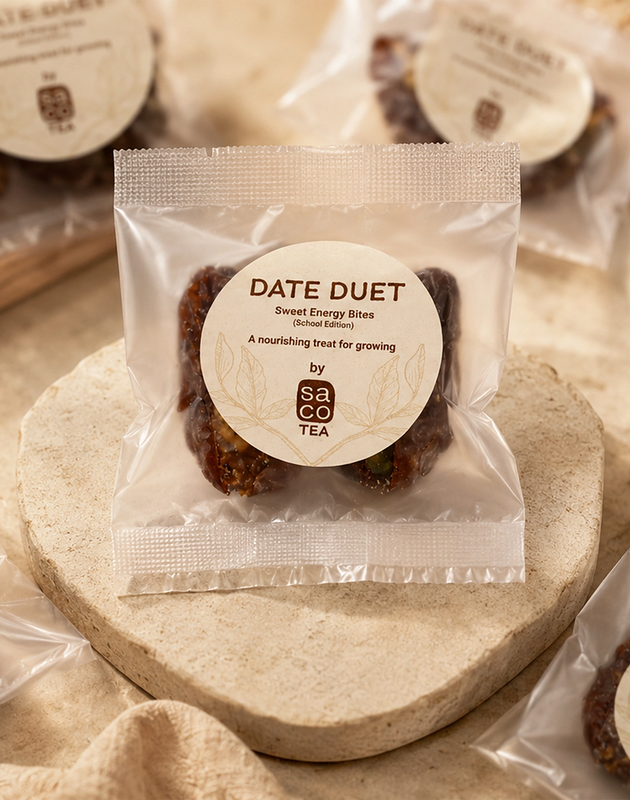 Packaged Date Duet bites with Saco Tea label on a stone surface
