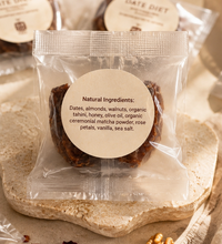 Date Duet stuffed dates in clear packaging with natural ingredients label on a textured stone plate.