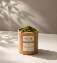 Container of matcha green powder with a label on a neutral background