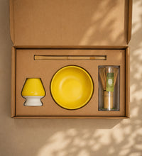 Open Saco Tea matcha gift box with yellow ceramic bowl, bamboo whisk, whisk holder, and bamboo scoop.